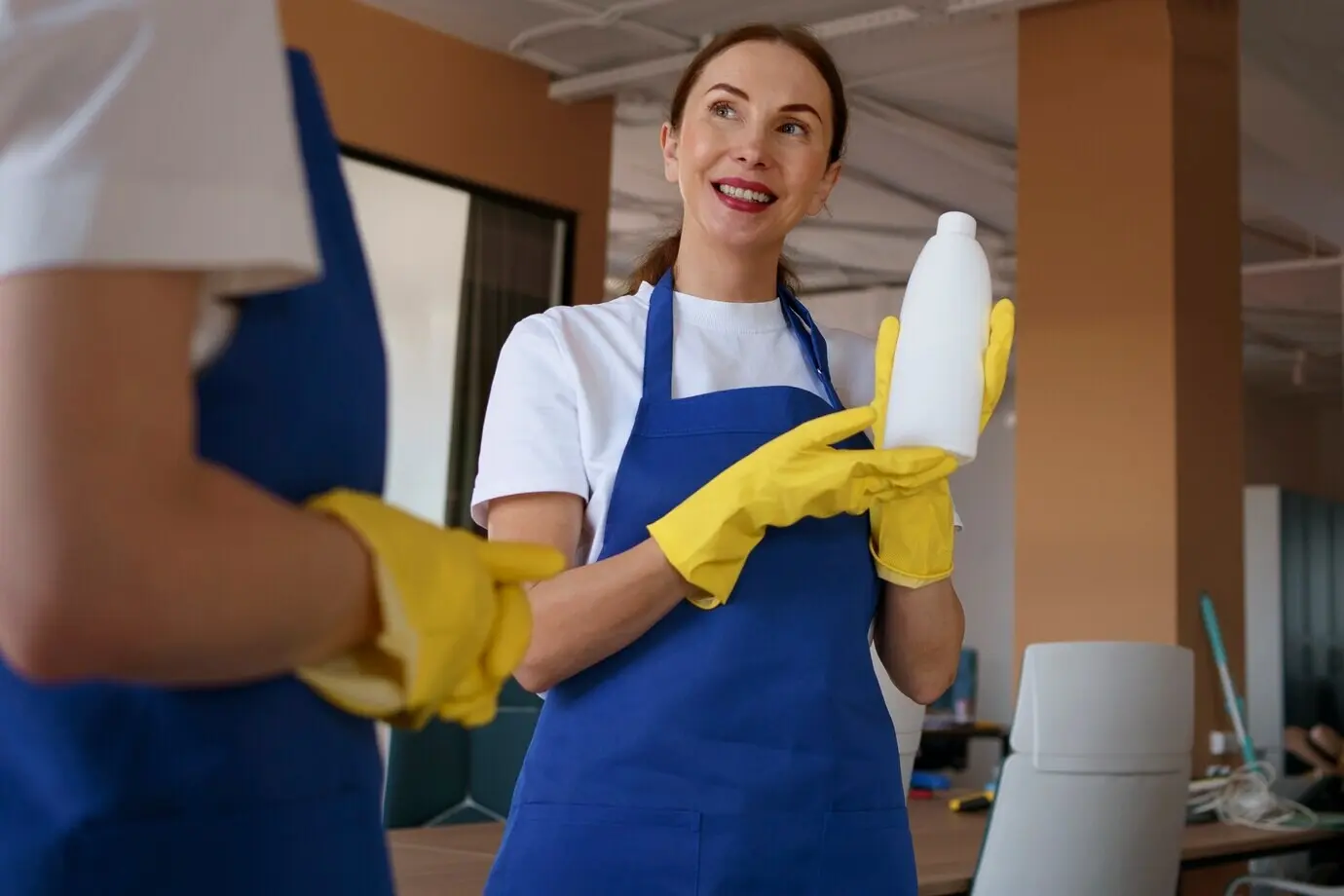 Сотрудники профессиональной клининговой службы совместно работают в офисе.